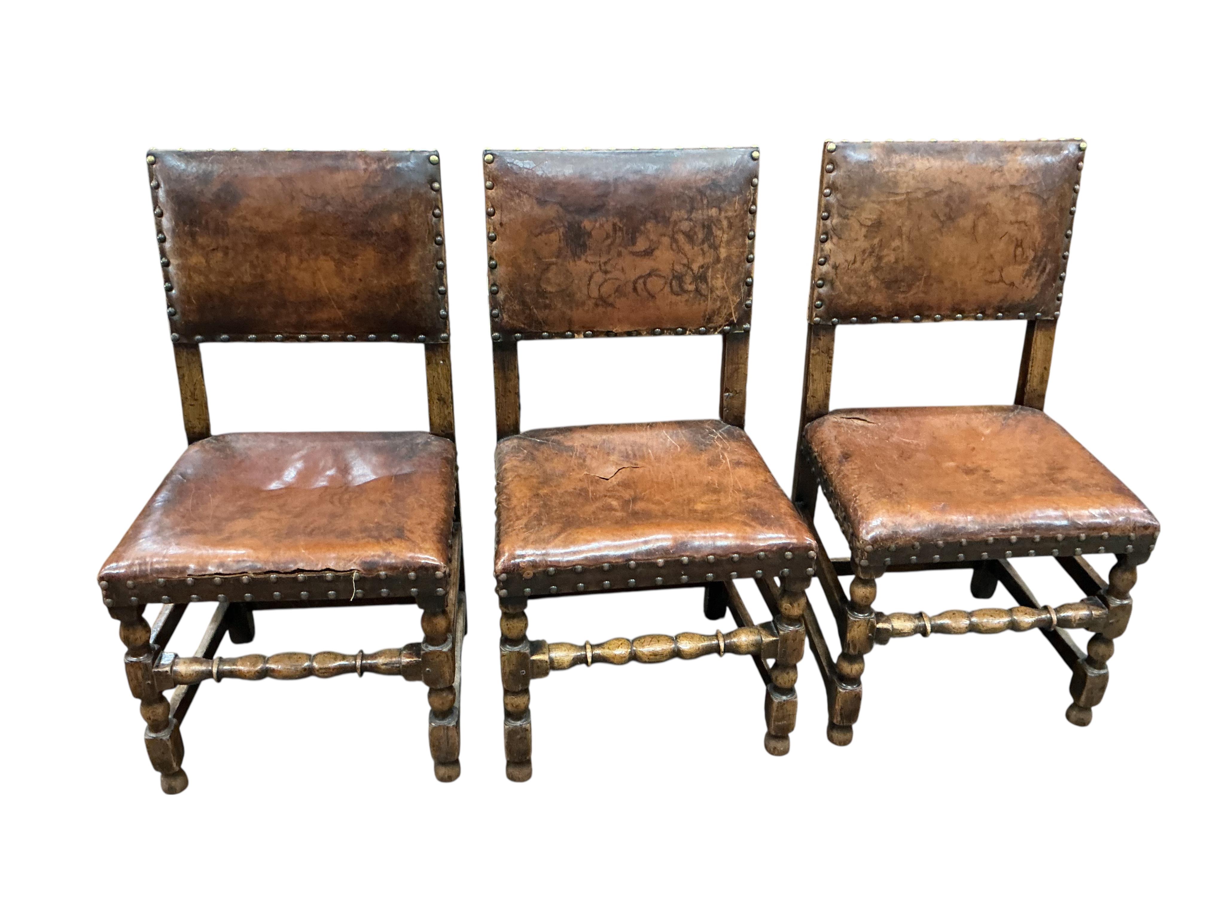 A set of eight Cromwellian style oak and tan leather dining chairs, two with arms